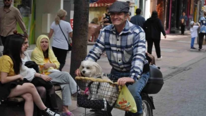 Köpeğini bisikletinin sepetine koyup güzel havanın tadını çıkardı