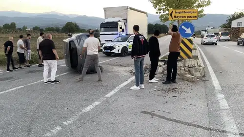 İnegöl'de ani manevra faciaya yol açtı: Refüje çarpan otomobil devrildi